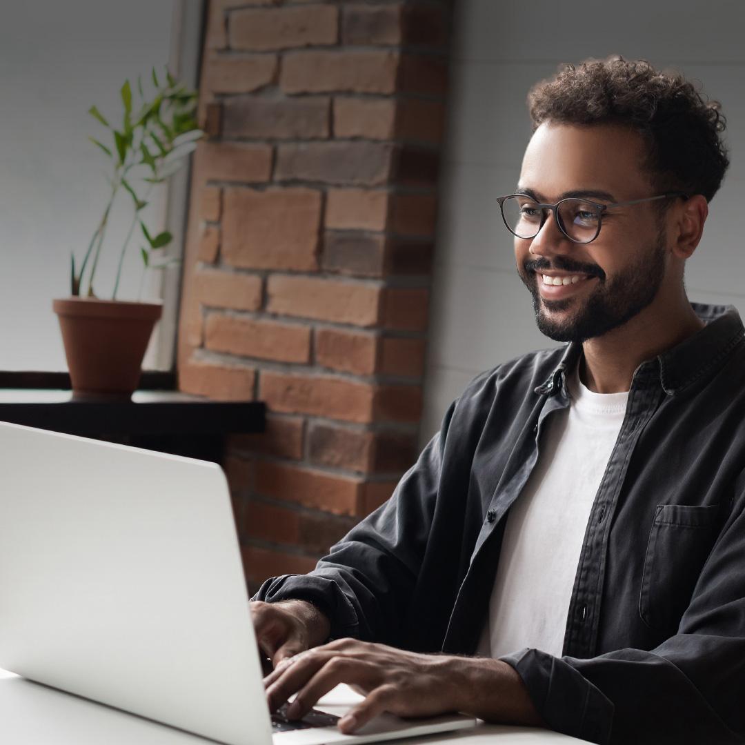 person smiling and sitting at computer